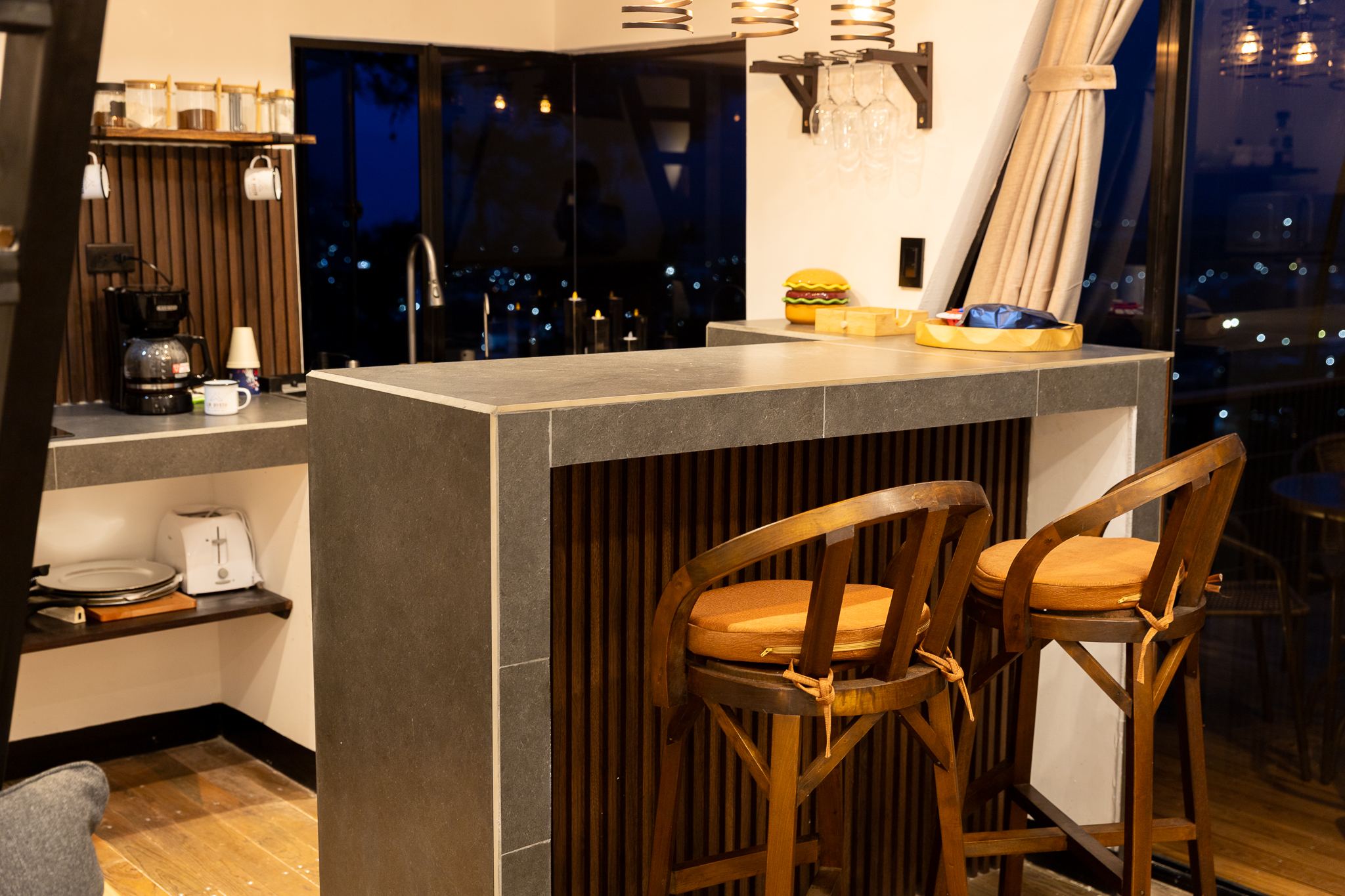 Desayunador de la cocina con bancos de madera y vista nocturna